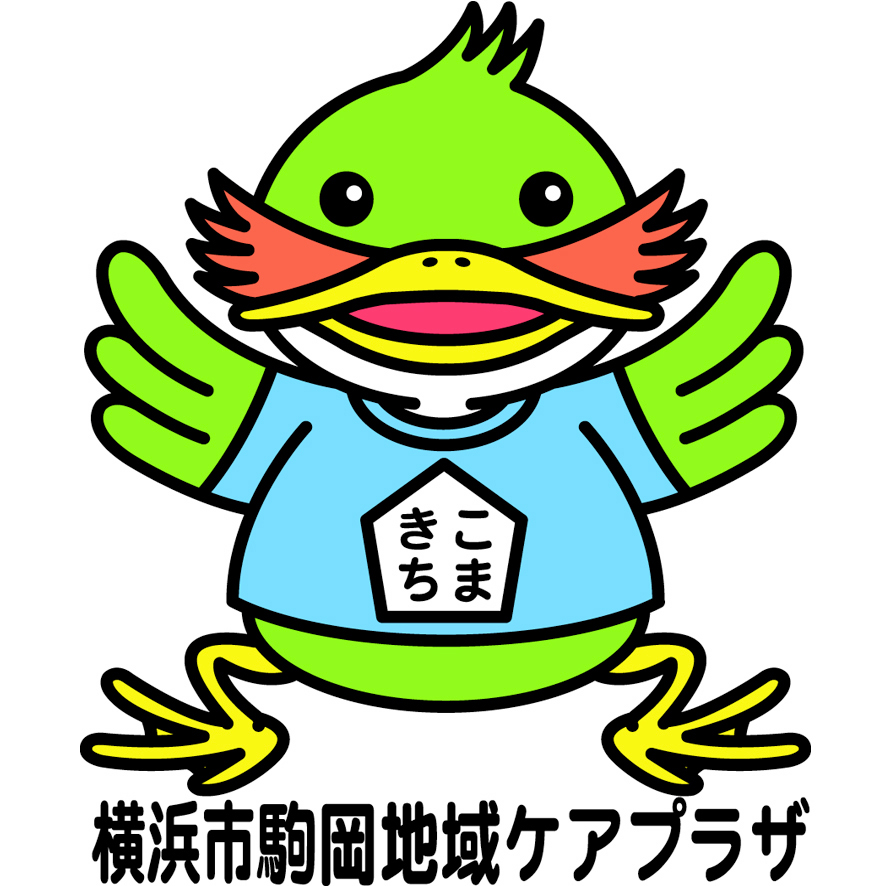 こまきち。黄緑色の鳥のキャラクター。黄色いくちばしと足、オレンジ色の耳のような羽をもち、「こまきち」と書かれた水色のシャツを着て、両手を広げて笑っています。足もとに「横浜市駒岡地域ケアプラザ」と書かれています。